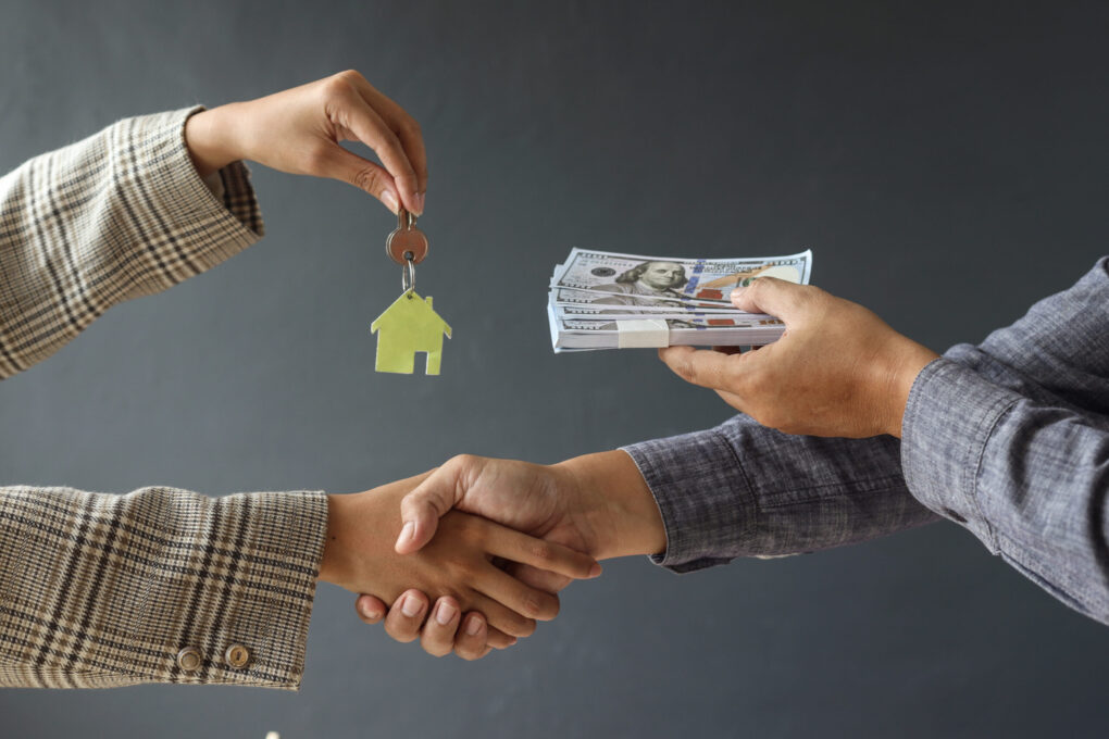 Home Seller Exchanging Keys For Cash With Wyoming House Buyer