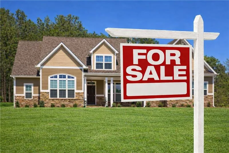 Home for sale sign in front of single family house